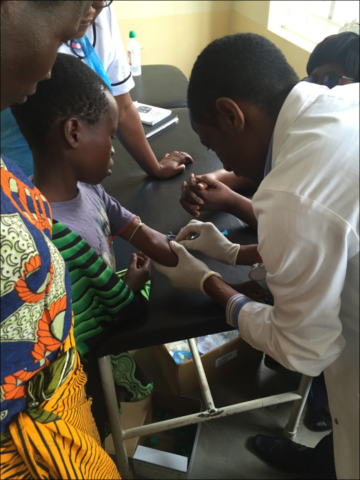 Image of a Malawian medical student drawing blood to test for malaria.