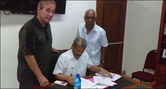 Fritz Deshommes signing docs for OD school in Haiti